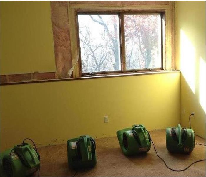 Four air movers drying a wall